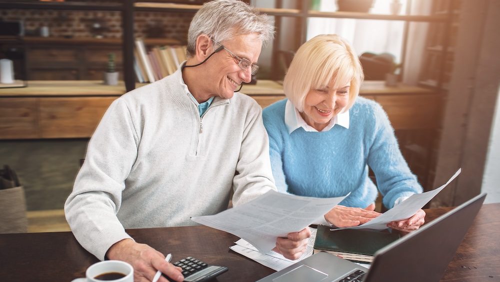 Nice picture of senior man and woman studying papers at the table. The are doing that together with pleasure.